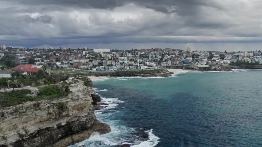 Residents of a neighborhood overlooking the ocean take advantage of the view by lying on the beach and using walking trails