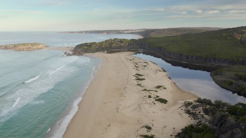 Aerial view of a beach with waves rolling in to the shore