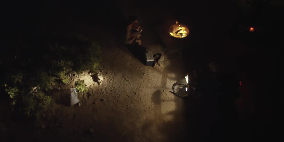 A motorcyclist turning onto a dirt road at night