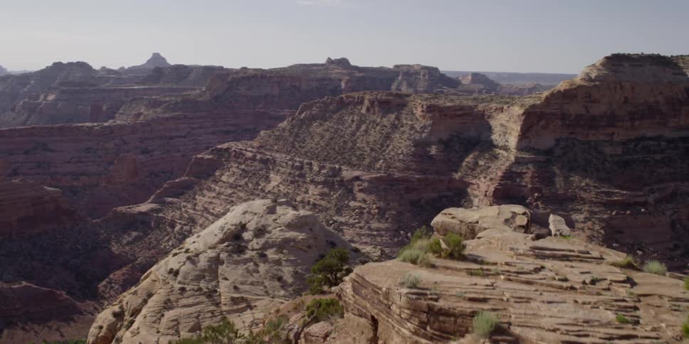 Two people are leaning on their motorcycles looking over a large canyon