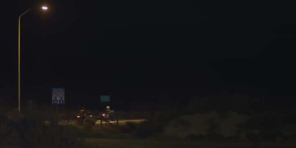 Motorcycles are driving down a road at night