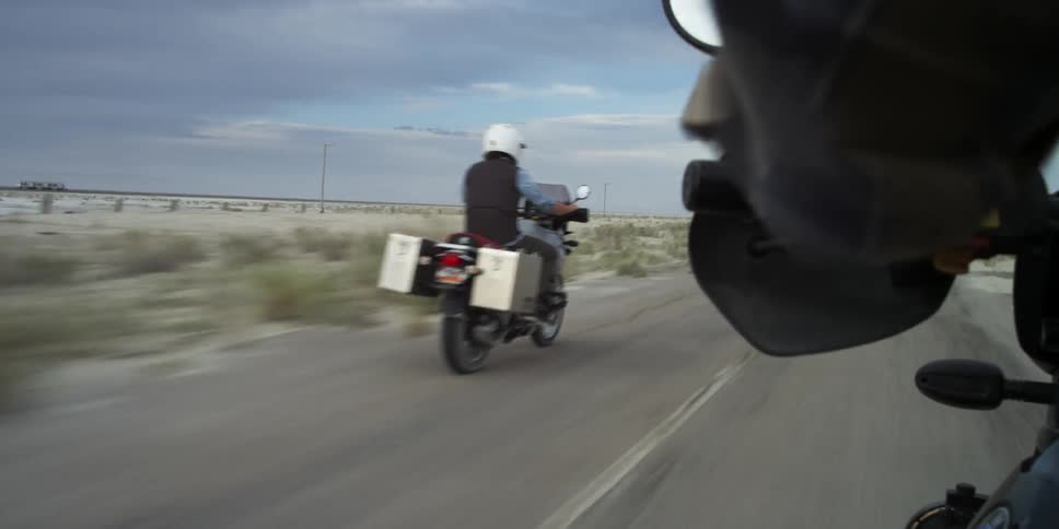 View from the side of a moving motorcycle on a cloudy day