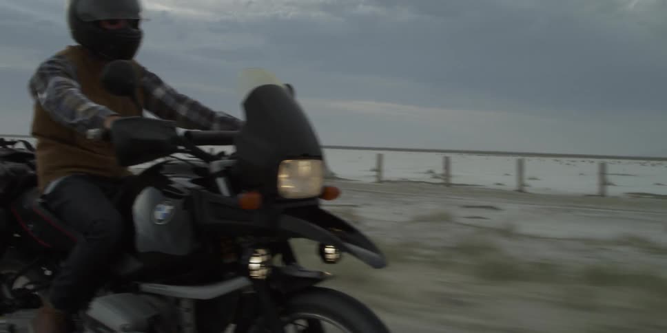 A person rides a motorcycle on a deserted road