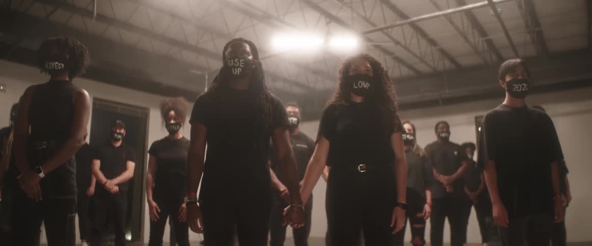 A group of people stand in protest racism in a basement wearing face masks