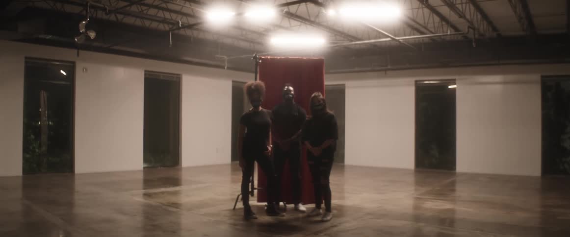 Group of people wearing face masks pose for the camera in a studio at night