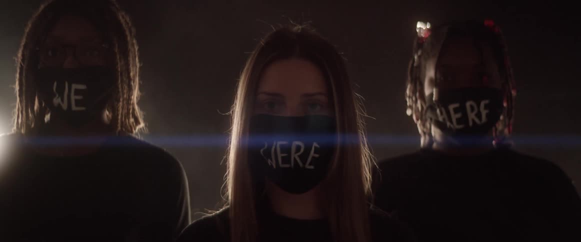 Group of young woman wearing face masks with text written over standing in a dimly lit room with strobing lights