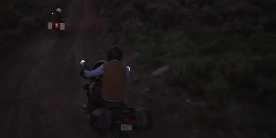 People ride motorcycles up a trail at night