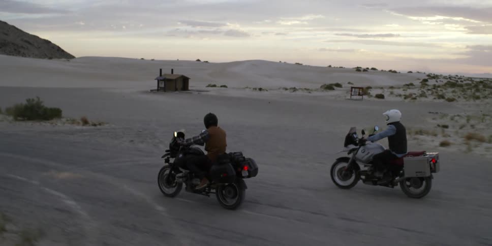 Two people riding motorcycles in the desert