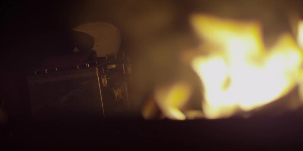 The flames of a fire burning and something in the background