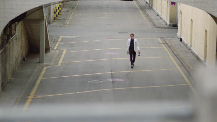 A man is walking on an empty street during the day