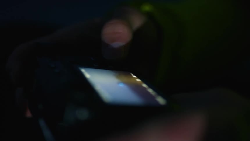 A person looks at photos on the screen of their camera