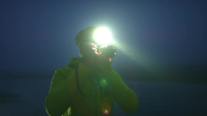 A man is photographing outside at dusk
