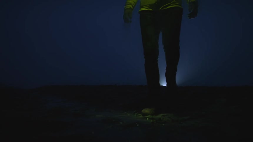 A man is walking outdoors at night