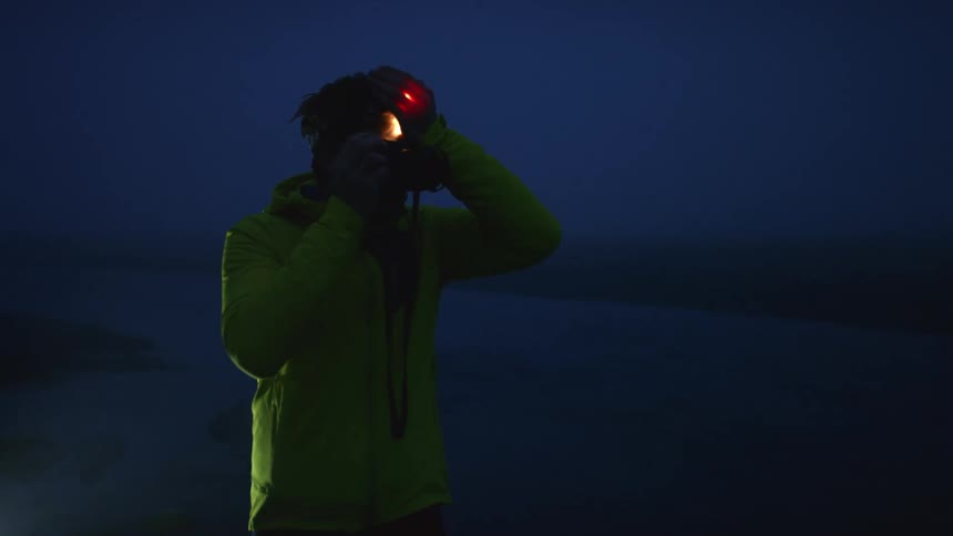 A man is taking a photo at dusk