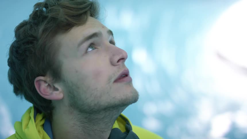 A man looks up and to the right then smiles
