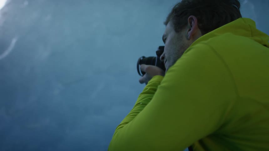 A man takes pictures of an ice berg