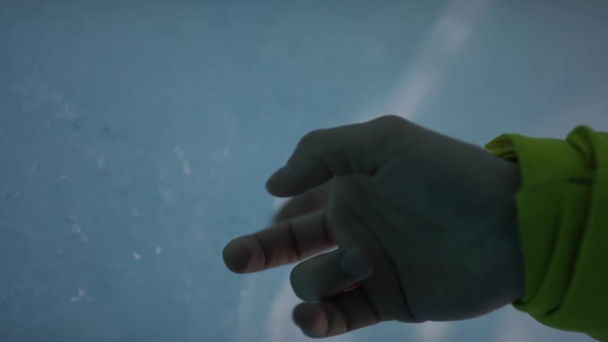 A person is touching ice outdoors