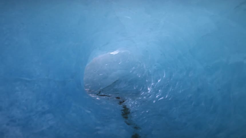 An ice tunnel with dirt reflecting sunlight