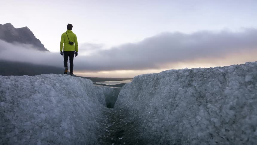 A man is hiking over the ice