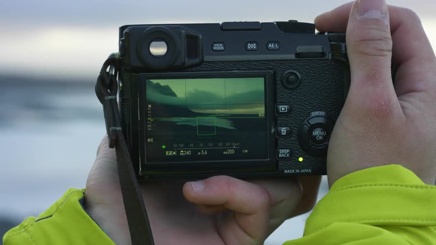 A man taking a photo of a mountain with a camera