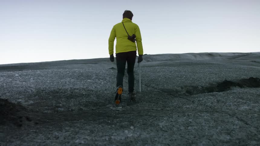 A man walks up the hill on a cloudy day