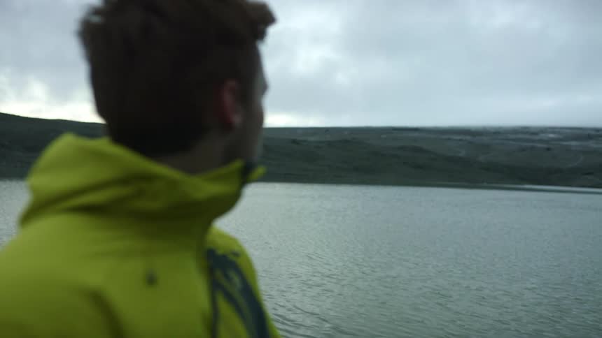 A man standing and looking out at the water