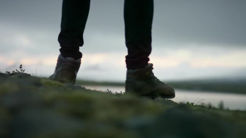 A man standing on the shore looking at the water