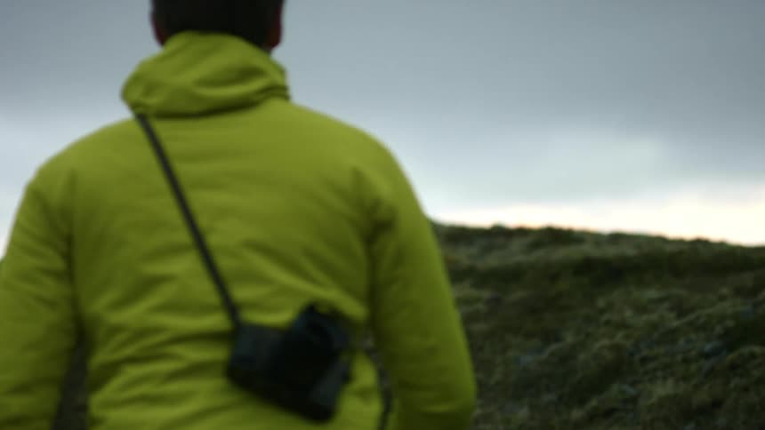 A man is walking up hill during the day