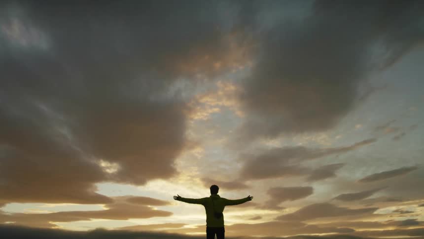 A man standing in front of a sunset