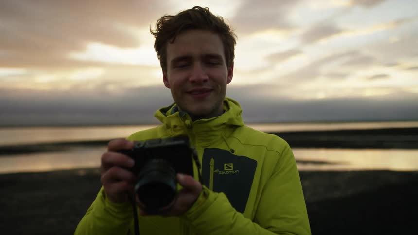 A man using a camera at the top of a hill