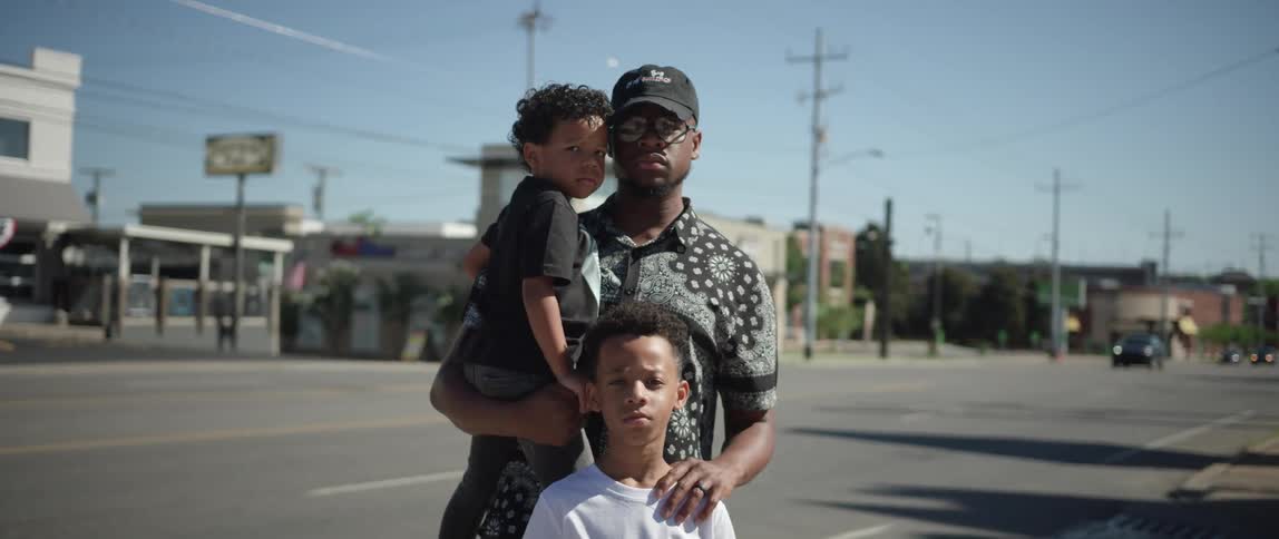 Father stands with his sons on the street of a small town at day