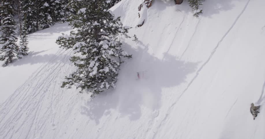 A snowboarder does a flip and crashes in the snow