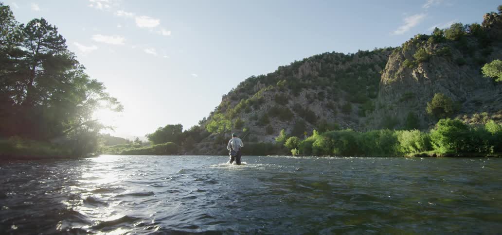 A man fly fishing standing in a river