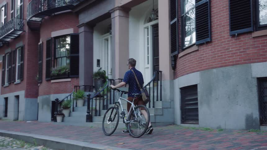 A man pushes his bicycle down the street