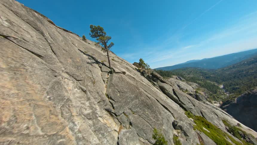 The steep stone slope of a mountain covered in patches of vegetation
