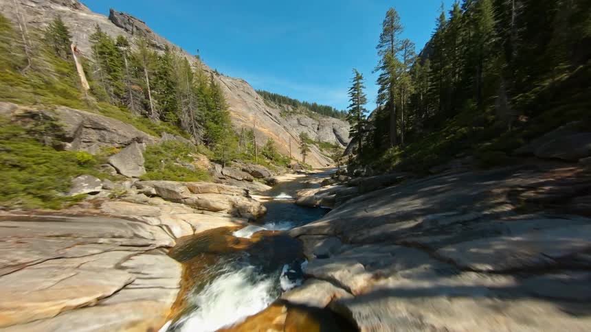 Mountain stream flowing through rocky canyon between mountains