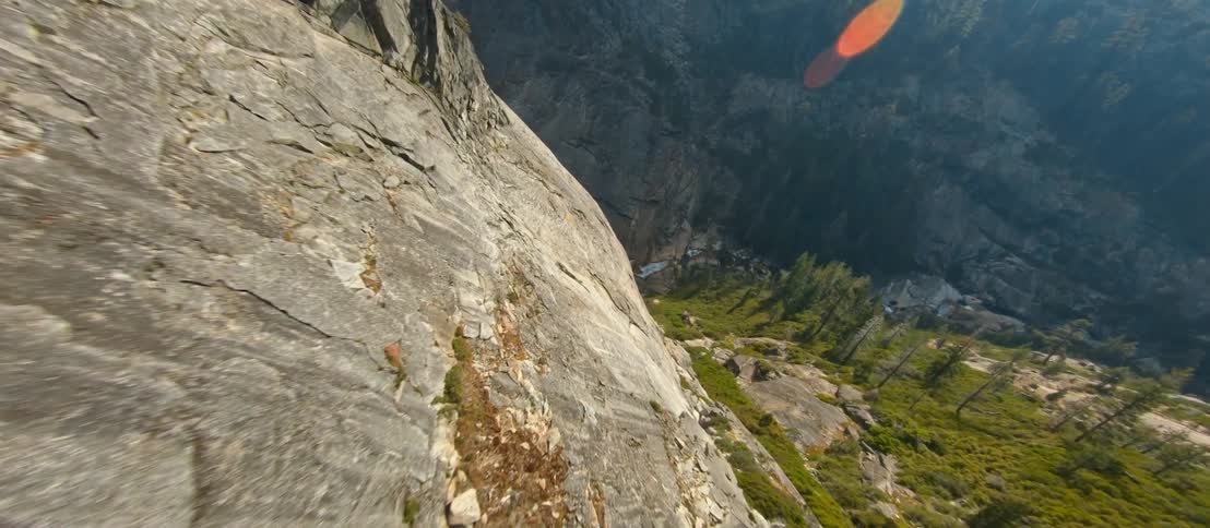 An aerial view of rock and pine trees in mountains in the daytime