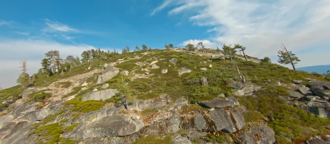 A mountain slope covered in stone and vegetation on a sunny day