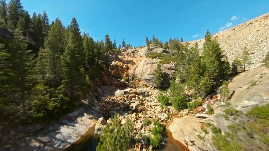 A pipeline in the mountain sprays water into the stream