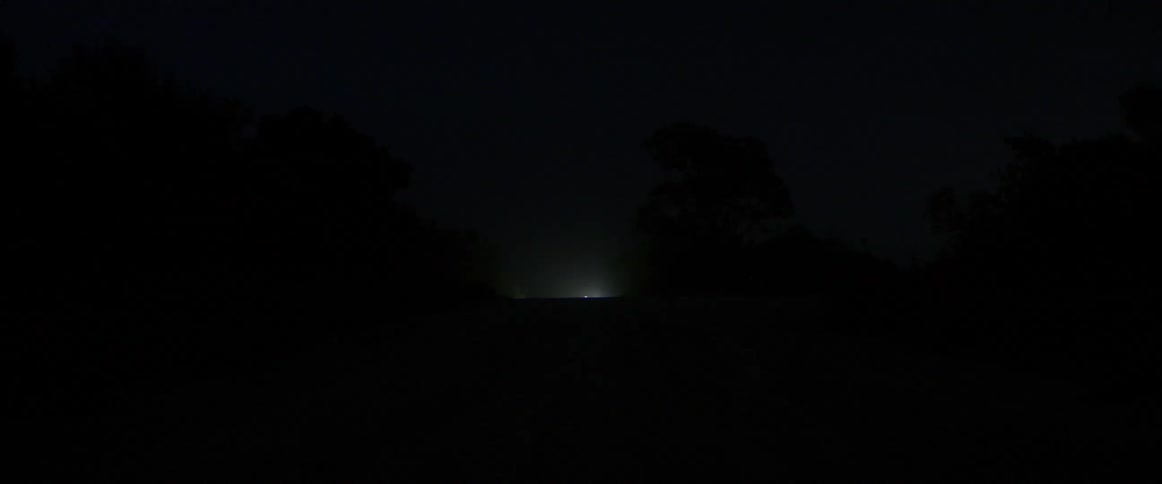 A vehicle headlight shining at night