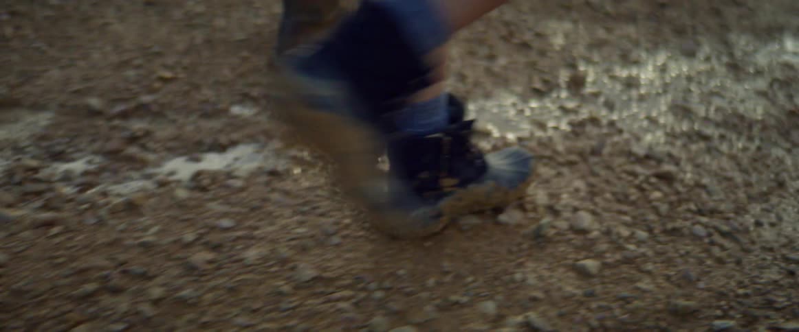 People in boots walking down muddy path