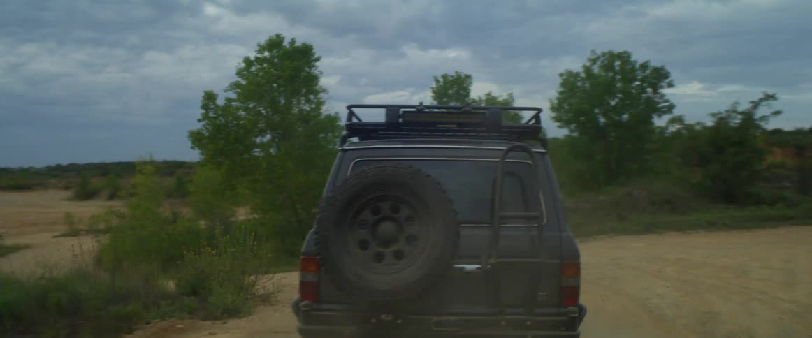 A truck driving off road on a trail