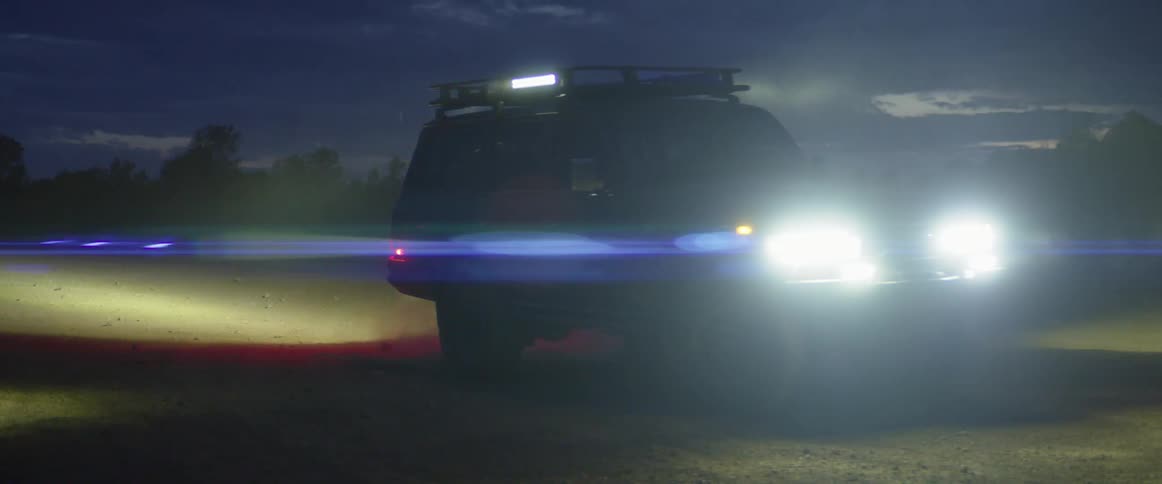 A car is driving outdoors at night
