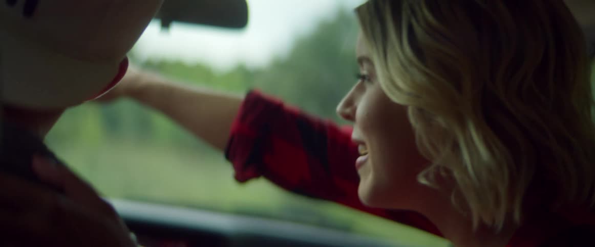 A woman talks with the driver as they travel