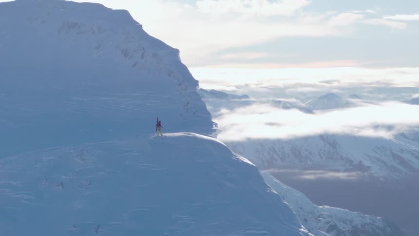 A person is standing on the cliff near the mountain top
