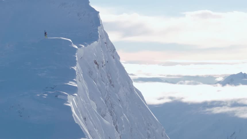 A lone hiker climbing up a snowy mountainside on a winter day