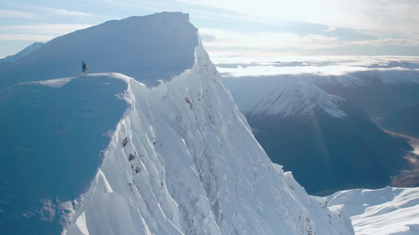 A person with skis is on top of the mountain