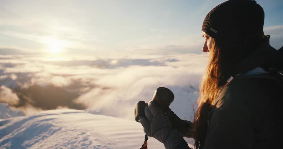 A woman is taking a photograph on the mountain top