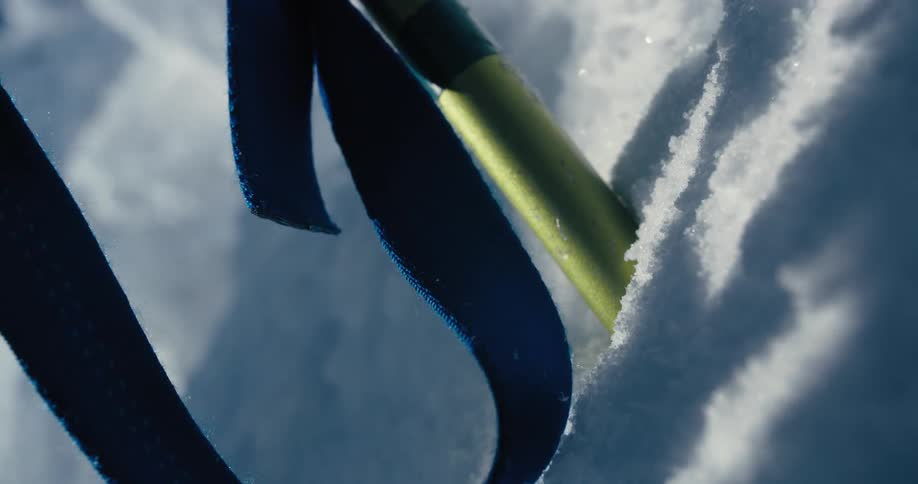 A person sticking a stake into the snow and ice