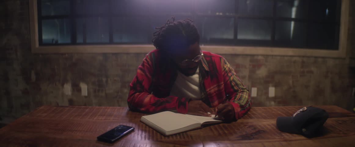 A man is writing in a journal at night